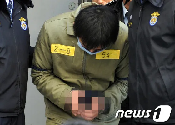자매를 살해한 혐의로 재판에 넘겨진 김홍일이 2013년 1월 25일 울산지방법원에서 열린 공판에서 사형선고를 받고 받고 고개를 숙인채 구치소 직원들 호송을 받으며 법원 청사를 나서고 있다. /사진=뉴스1