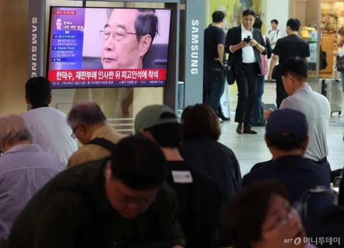 [서울=뉴시스] 황준선 기자 = 30일 오전 서울 중구 서울역 대합실에서 시민들이 '내란방조 혐의'로 특검에 기소된 한덕수 전 국무총리의 첫 재판을 시청하고 있다. 2025.09.30. hwang@newsis.com /사진=황준선