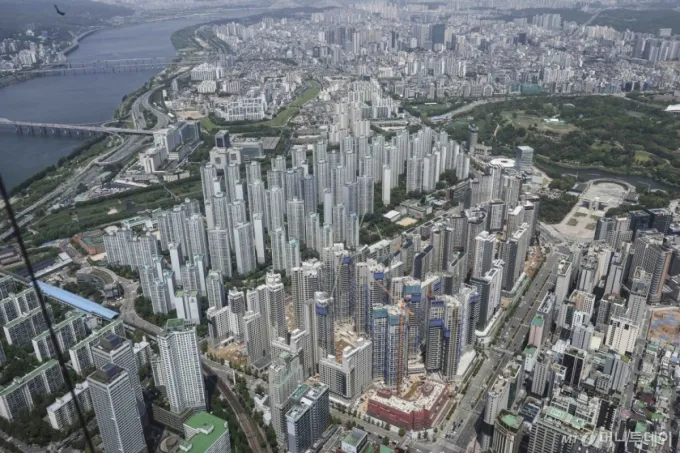 [서울=뉴시스] 김근수 기자 = 7일 서울 송파구 롯데월드타워 스카이전망대에서 잠실 주변 아파트 단지와 재건축 아파트 현장이 보이고 있다.  토지거래허가구역 재지정 이후 재건축 아파트를 중심으로 신고가 행렬이 이어지는 가운데 송파구의 잠실 장미아파트와 주공5단지에서 신고가가 집중됐고, 잠실주공5단지 82.6㎡가 처음으로 40억원을 돌파했다. 강남구 압구정에서도 거래 22건 중 14건(64%)이 신고가였으며, 개포동의 거래 4건 모두 신고가를 기록했다. 대치동 역시 한보미도맨션2차 190㎡가 60억원, 개포우성1차 127㎡가 50억5천만원, 은마아파트 76㎡는 31억4천만원에 거래되며 신고가를 이어갔다.. 2025.05.07. ks@newsis.com /사진=김근수