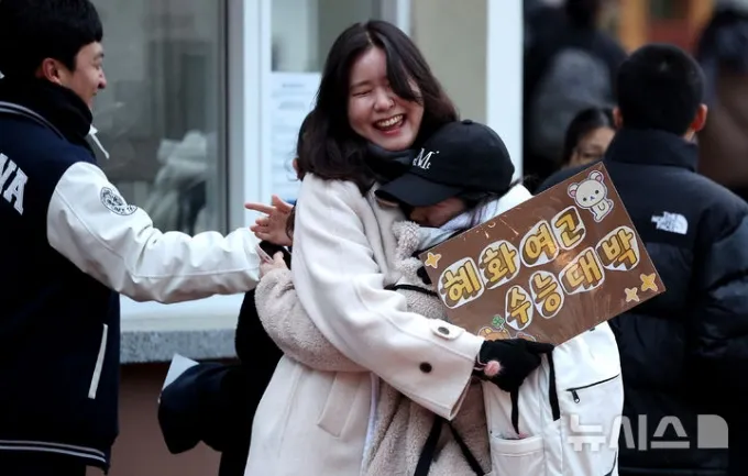 수능을 망친 딸에게 용돈 500만원을 준 아버지의 사연이 화제다. 2026학년도 대학수학능력시험일인 13일 대구 수성구 대구여자고등학교 수능 시험장 앞에서 응원을 나온 선생님이 수험생을 격려하고 있다. /사진=뉴시스